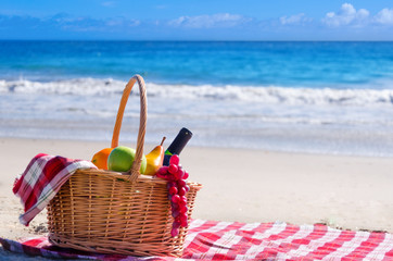 Picnic basket with fruits by the ocean