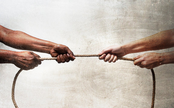 black ethnicity hands pulling rope against white Caucasian race