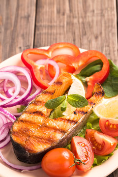 Grilled salmon steak with tomatoes vertical
