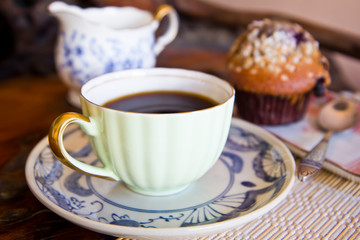 Banana muffin and a cup of coffee on wooden table
