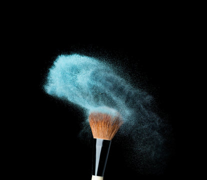 powderbrush on black background with blue powder splash