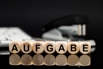 Aufgabe - Würfel vor Büromaterial