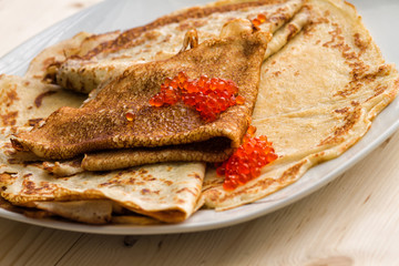 plate with pancakes and red caviar