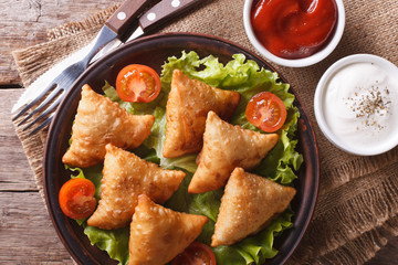 samosa on a plate with sauce closeup, horizontal top view