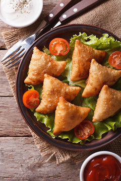 samosa on a plate with sauce closeup, vertical top view