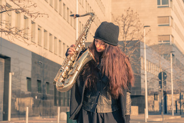 Beautiful young woman with her saxophone