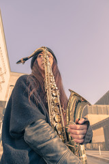 Beautiful young woman with her saxophone