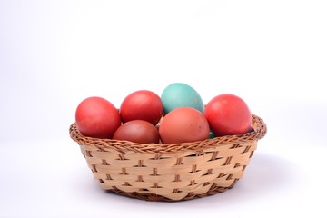 Colored easter eggs in basket. White background.