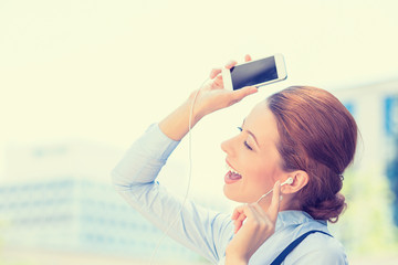 woman walking on street listening music on mobile smart phone