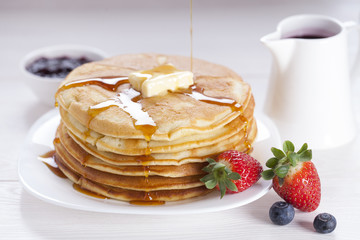 Delicious sweet American pancakes on a plate with fresh fruits