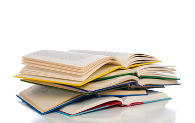 A stack of colorful, open books on a white background