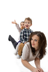 Mother giving her daughter and son piggyback ride against