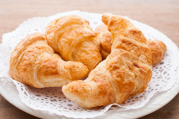 fresh croissants on wooden table