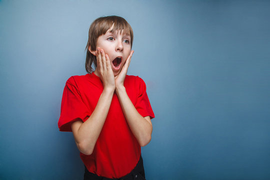 Boy, teenager, twelve years in  red shirt surprised open mouth