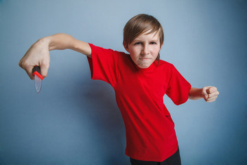 Teenager boy twelve years in the red t-shirt with a knife evil