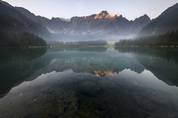 Jezioro alpejskie spowite porannymi mgłami - obrazy, fototapety, plakaty