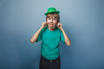 European appearance teenager boy in T-shirt with green hat stret