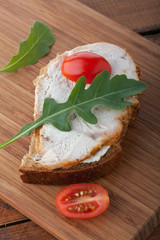 Sandwich with roasted turkey breast, tomato and arugula