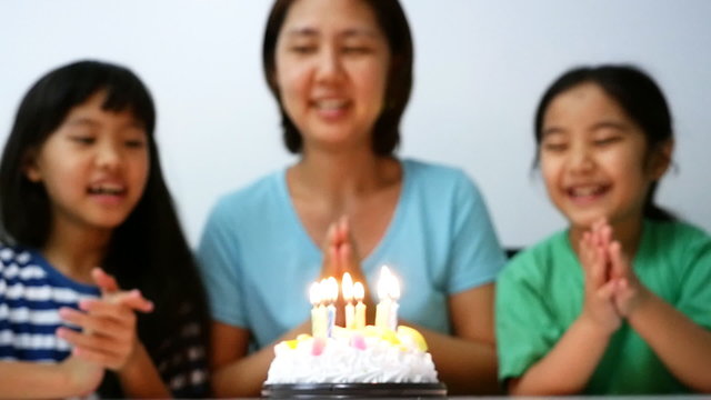 Slow motion of Asian family blowing birthday candles