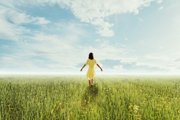 Young woman walking on summer meadow