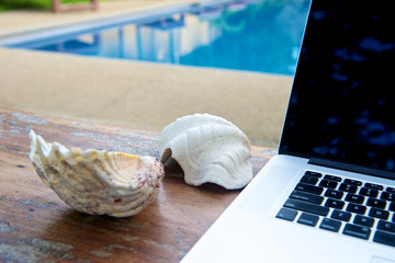 Vacation work with laptop at pool