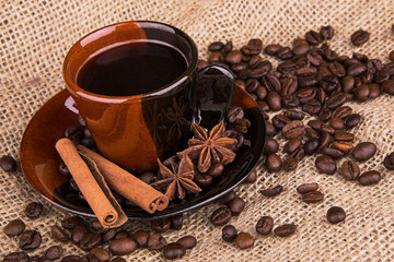 Coffee cup and beans on a wooden table. Dark background.