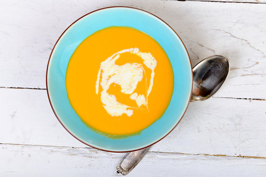 plate of pumpkin soup on a wooden table