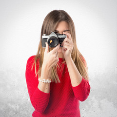 Girl taking a picture over white background