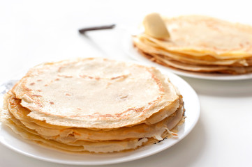 Many pancakes with butter on white background