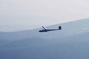 Segelflugzeug mit Wäldern am Horizont