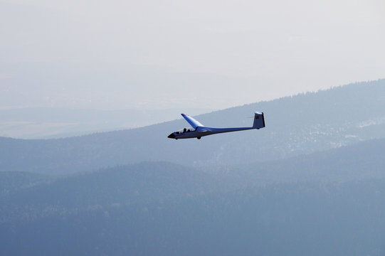 Segelflugzeug mit Wäldern am Horizont