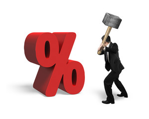 Businessman holding sledgehammer hitting red percentage sign iso