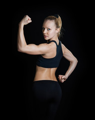 Fototapeta na wymiar Athletic young woman showing muscles of the back and arms