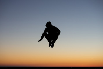 silhouetted dancer in sunset sky