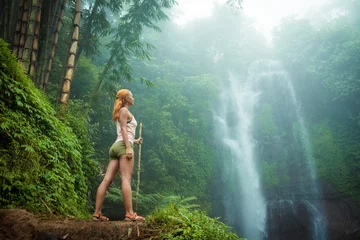 Poster Im Rahmen Weiblicher Abenteurer mit Blick auf Wasserfall © Ni23