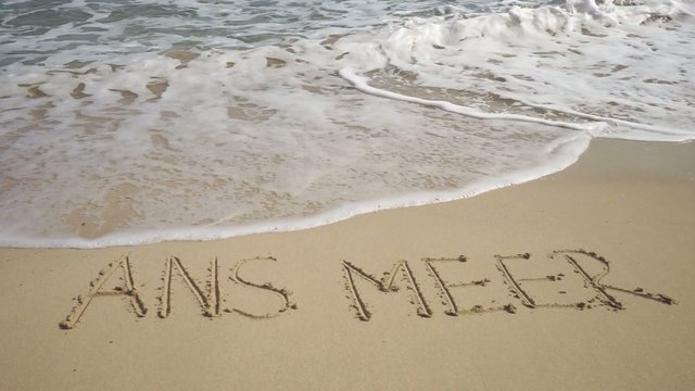 Text ANS MEER in Sand gezeichnet