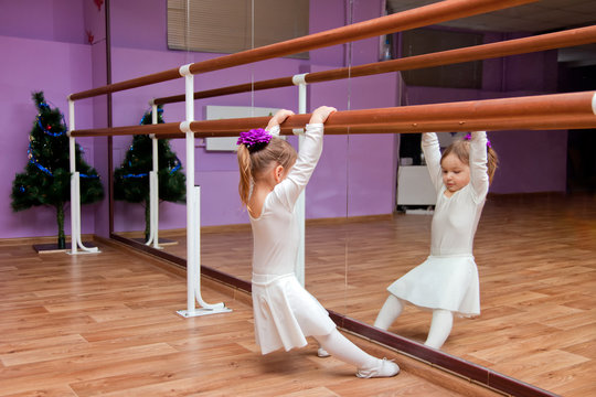 Ballet dancer little girl in class on the handrail