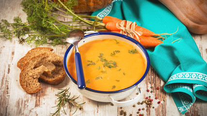 Rural pumpkin soup on rustic wood table