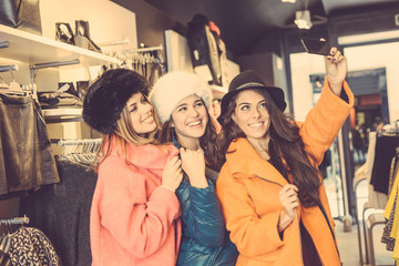 Three women taking a selfie wearing colorful coats