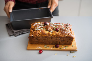 Closeup on young housewife showing freshly baked pumpkin bread
