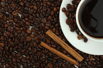 Cup with coffee on plate on coffee beans background