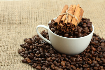 cup with coffee beans on sackcloth