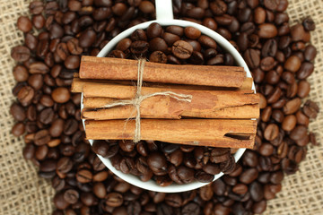 cup with coffee beans on sackcloth