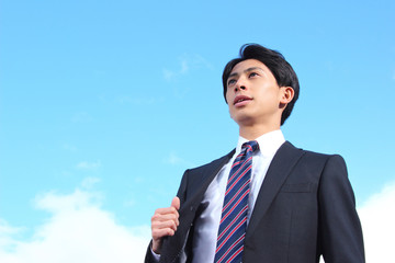 A businessman looking up at the sky