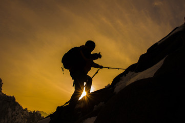 Silhouette of mountaineer and sunset.