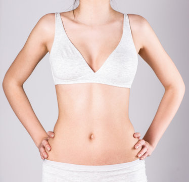 Slim woman's body over gray background