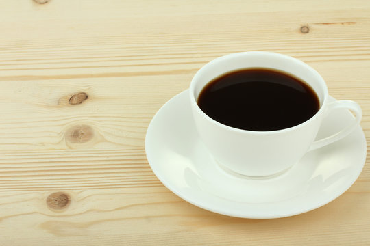 Cup of coffee on old white wooden table.