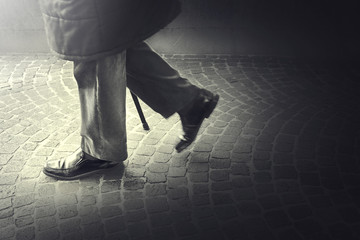 Old Man walking with his stick toward light - obrazy, fototapety, plakaty