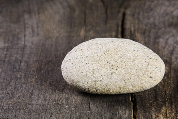 Fototapeta na wymiar Ein Stein auf Holz Hintergrund