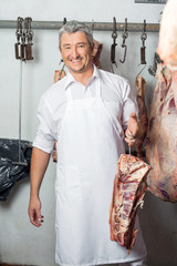 Butcher Holding Meat With Hook In Butchery